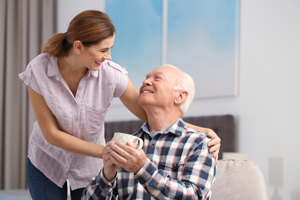 Elderly couple with female caregiver at home