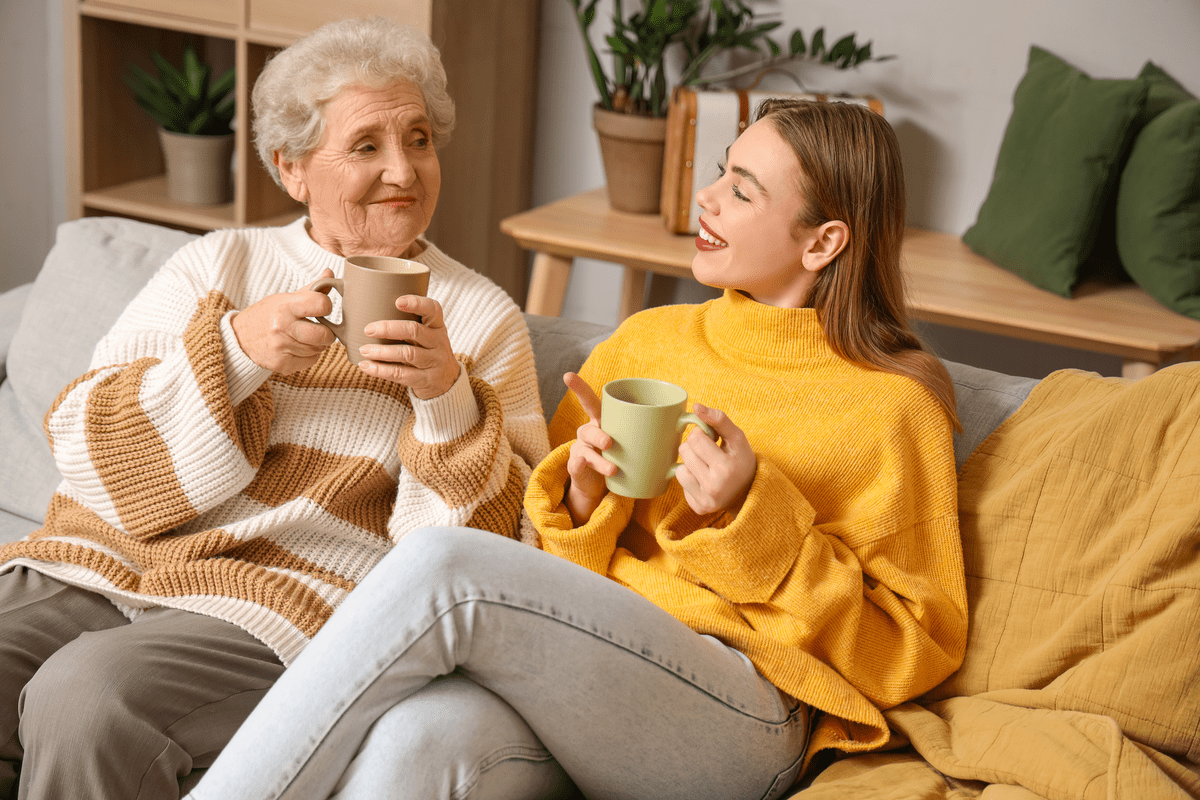 Young woman and her grandmother drinking tea at home