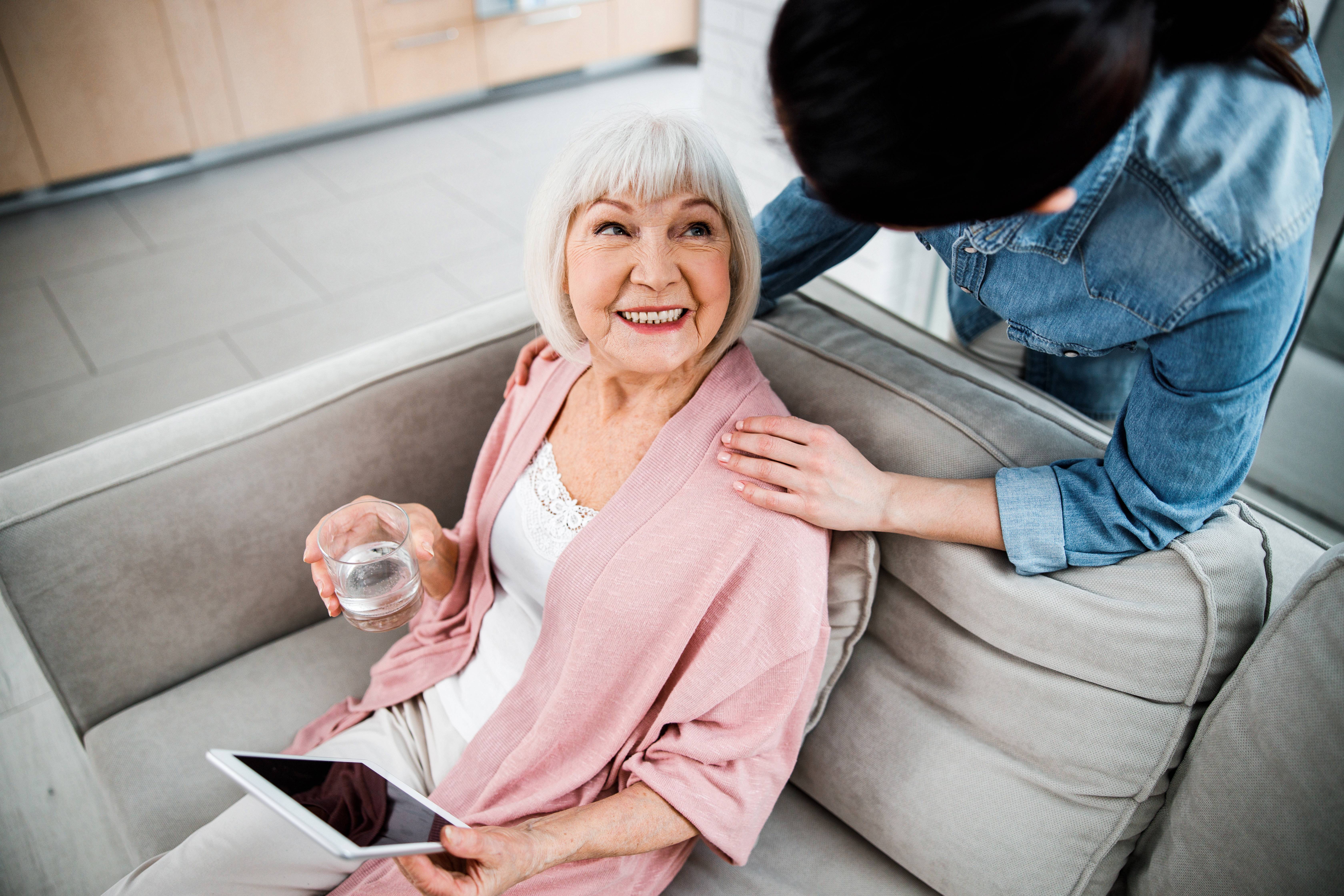 Old lady with gadget looking at granddaughter 